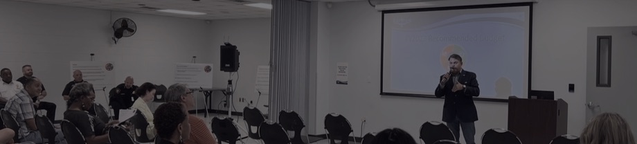A speaker in front of a seated audience